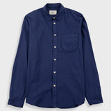 A navy blue long-sleeve button-up shirt with a single chest pocket, laid flat against a light gray background.