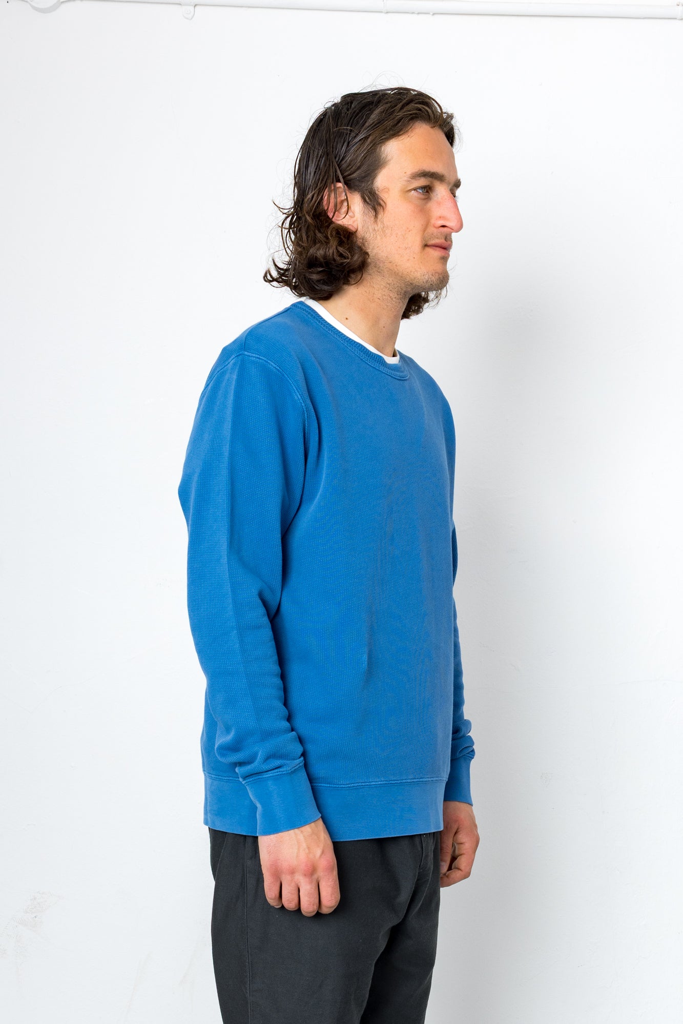 Person wearing a blue sweater against a white background