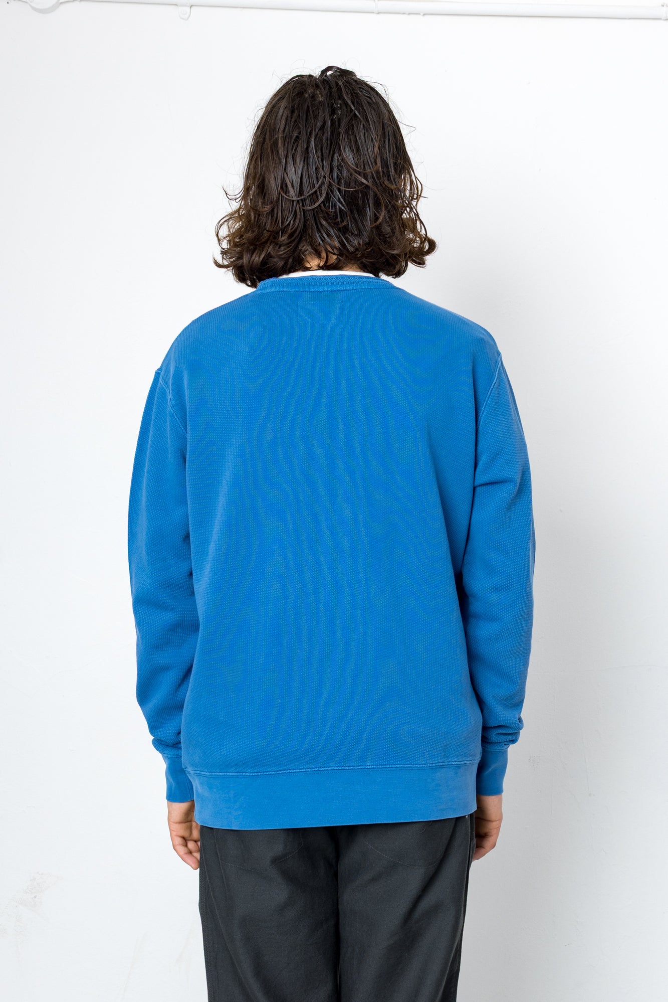Person wearing a blue sweatshirt on a white background