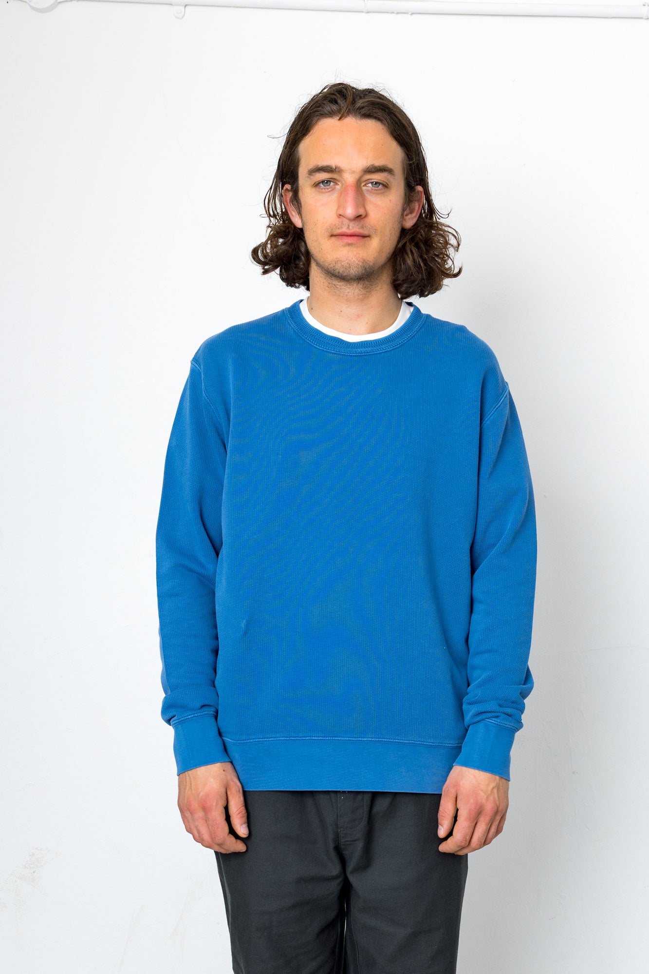 Man wearing a blue sweater against a white background