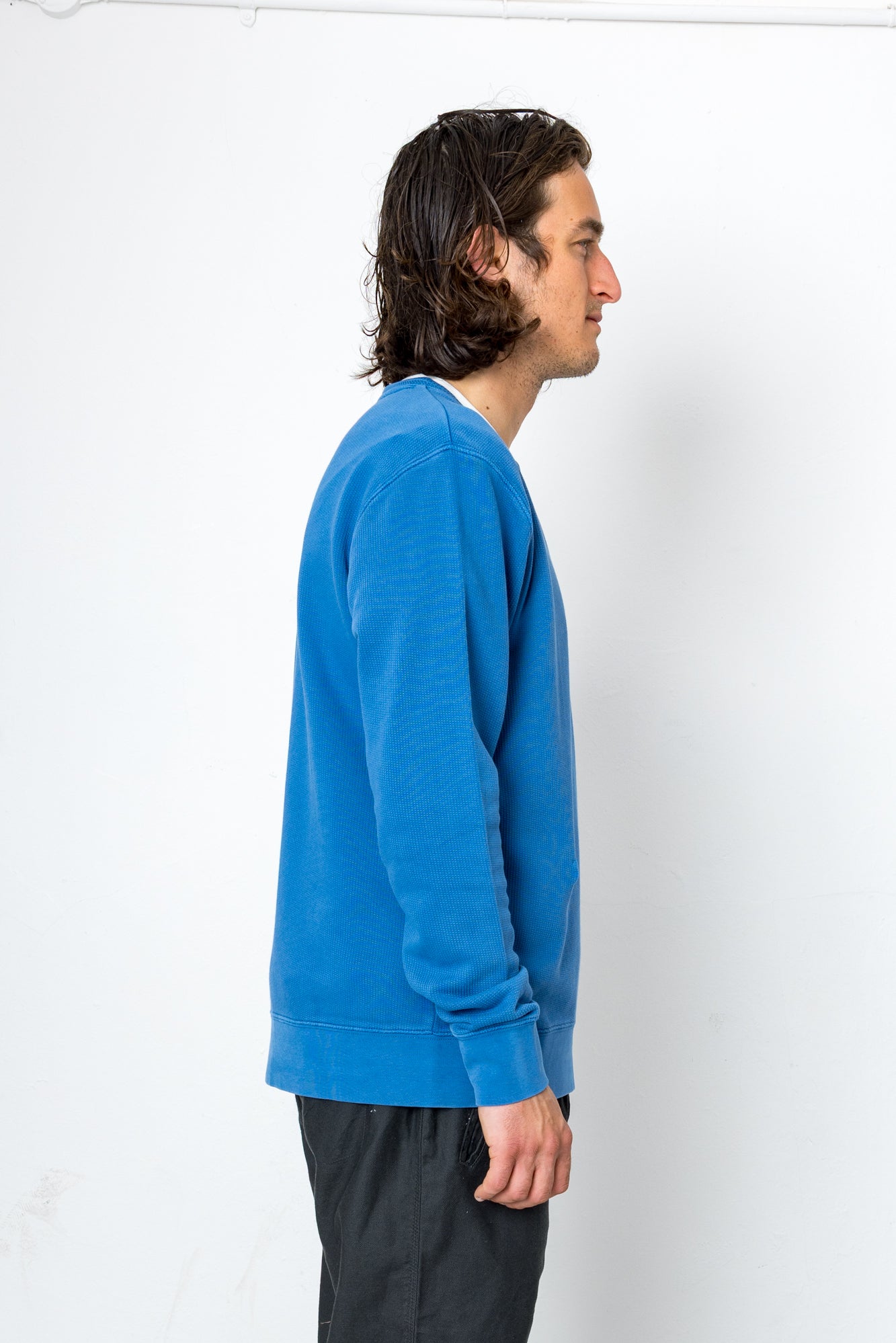 Person wearing a blue sweater against a white background