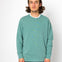 Person wearing a teal sweater with a white background