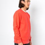 Person wearing a bright orange sweatshirt against a white background