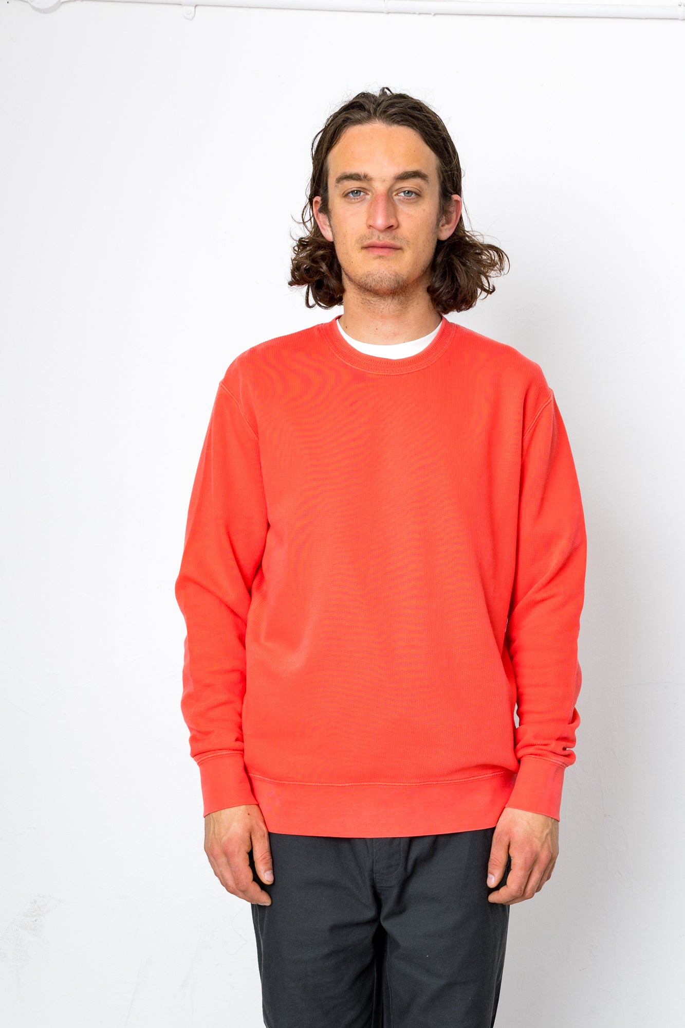 Person wearing a bright red sweatshirt against a white background