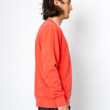 Man wearing a bright orange sweatshirt against a white background