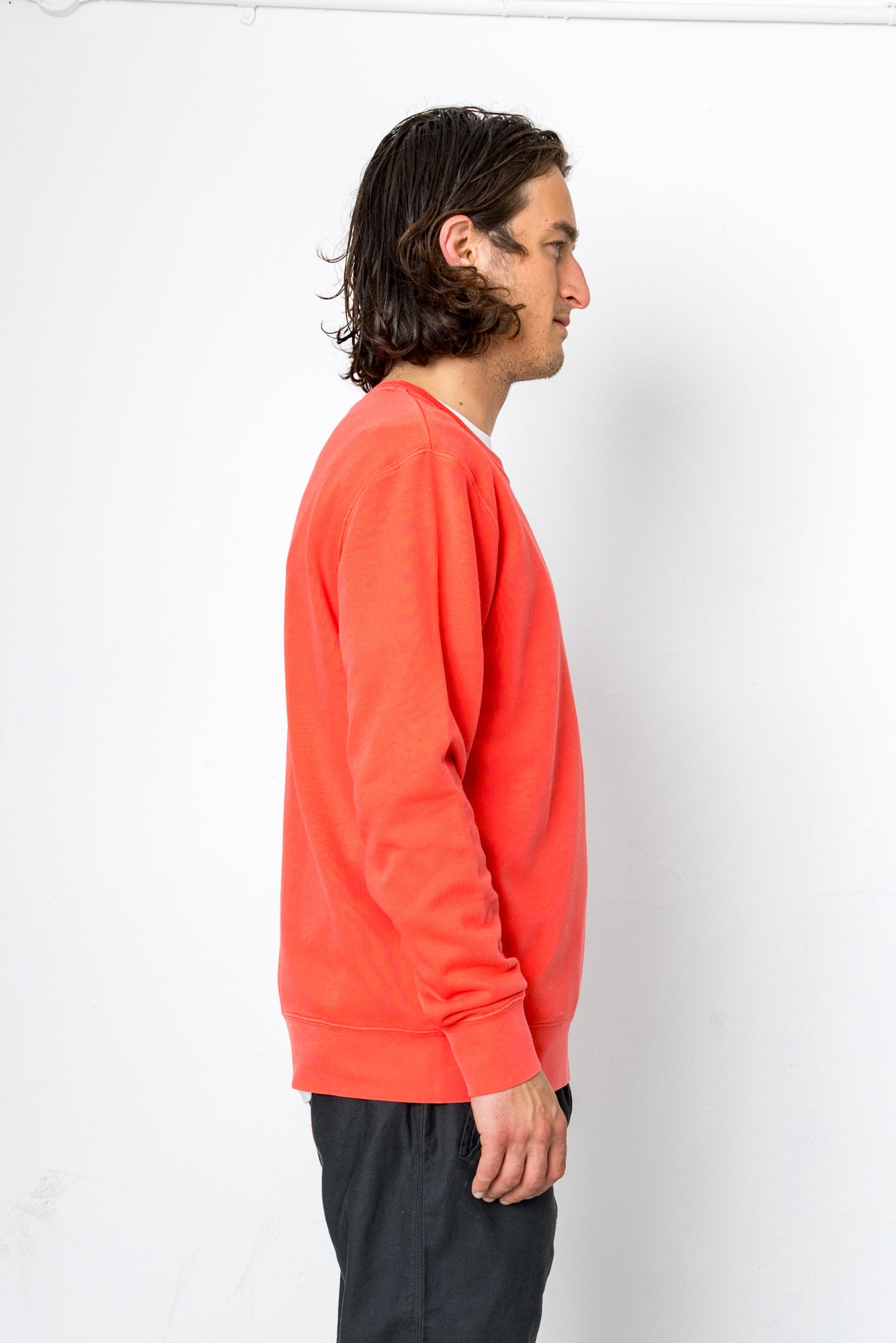 Man wearing a bright orange sweatshirt against a white background