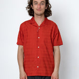 Man wearing a red short-sleeve shirt against a white background