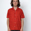 Man wearing a red short-sleeve shirt against a white background