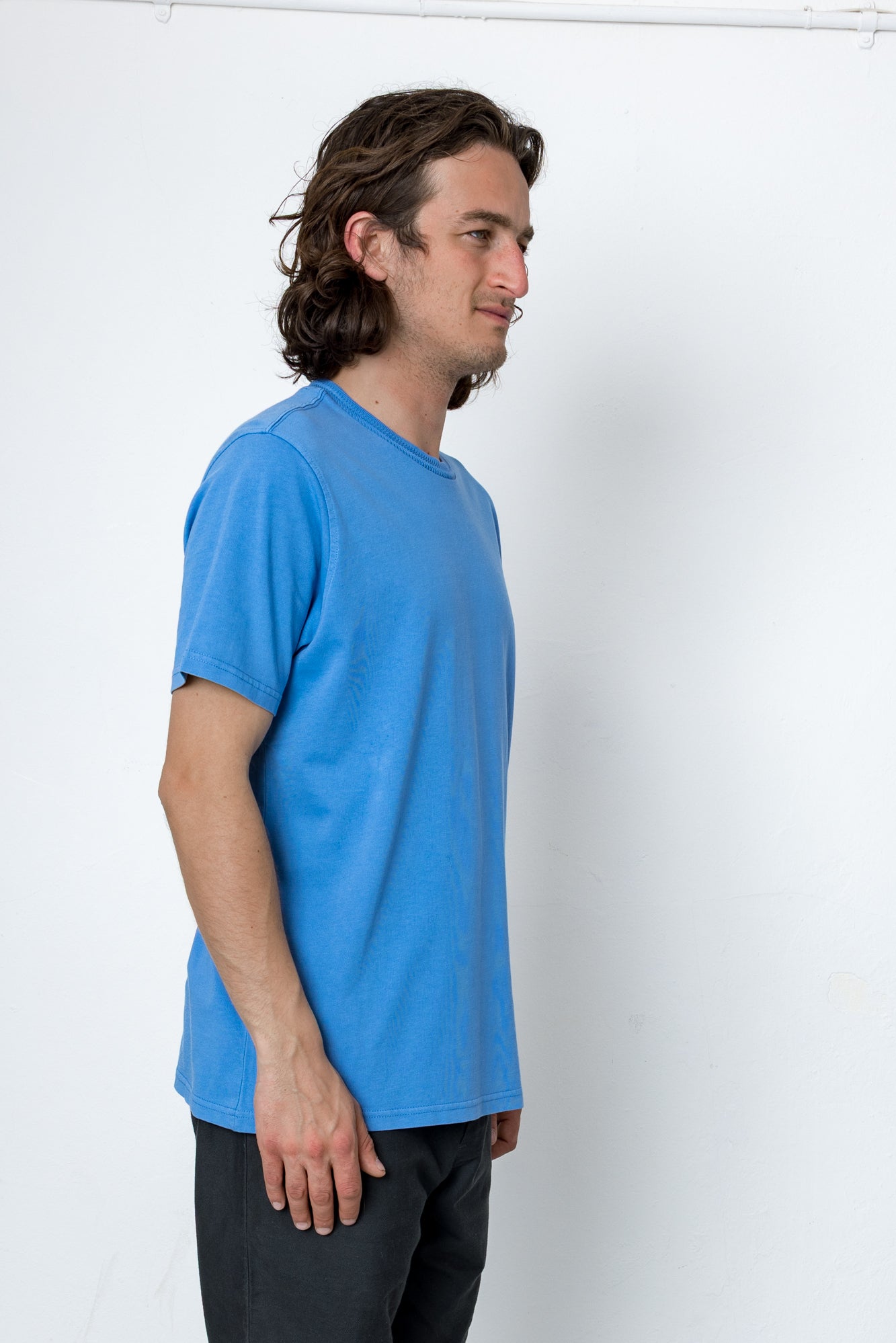 Man wearing a blue t-shirt against a white background
