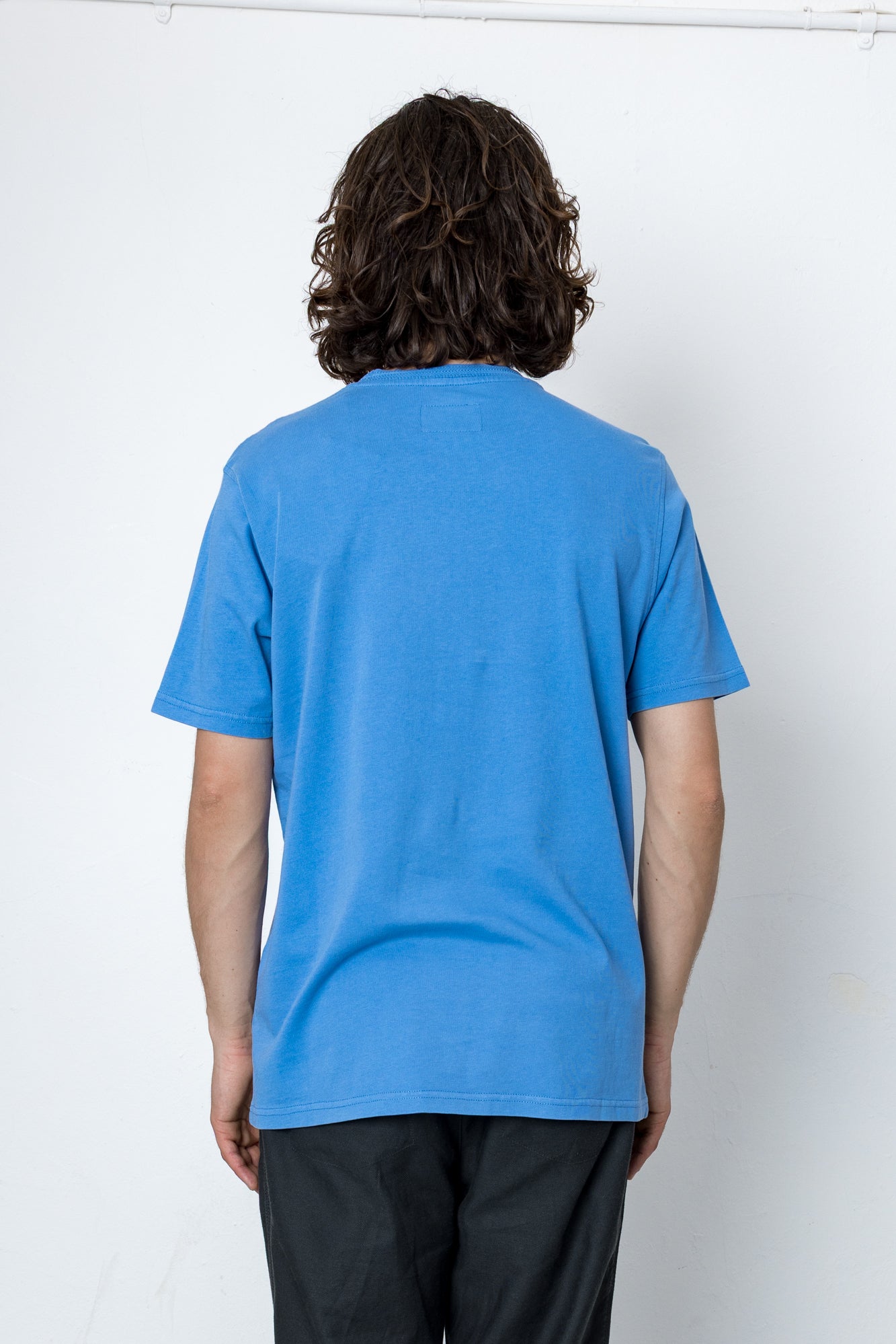 Person wearing a blue t-shirt against a white background