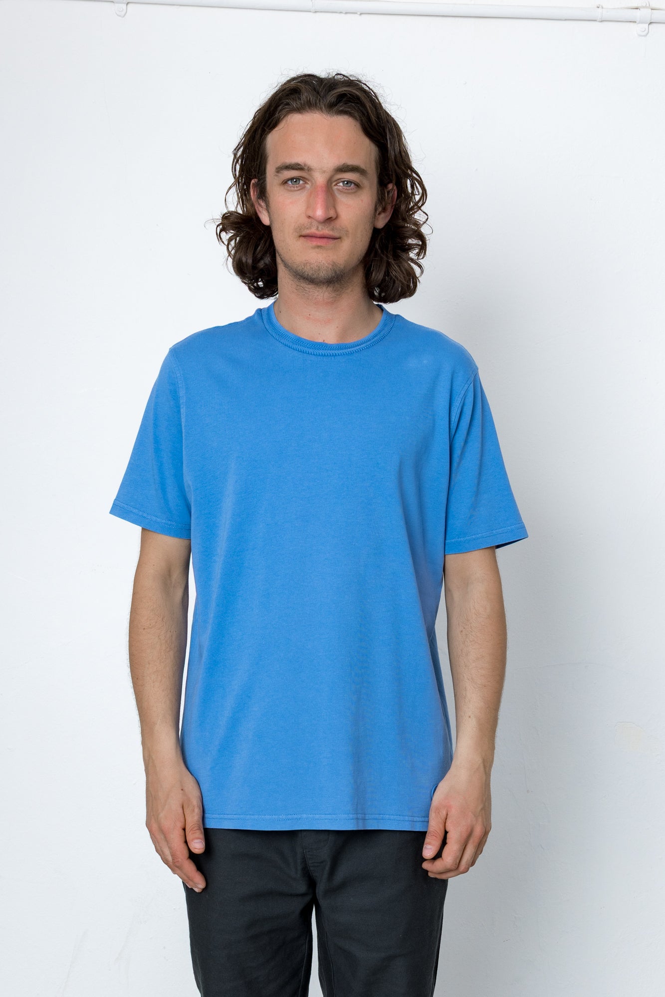 Man wearing a blue t-shirt against a white background