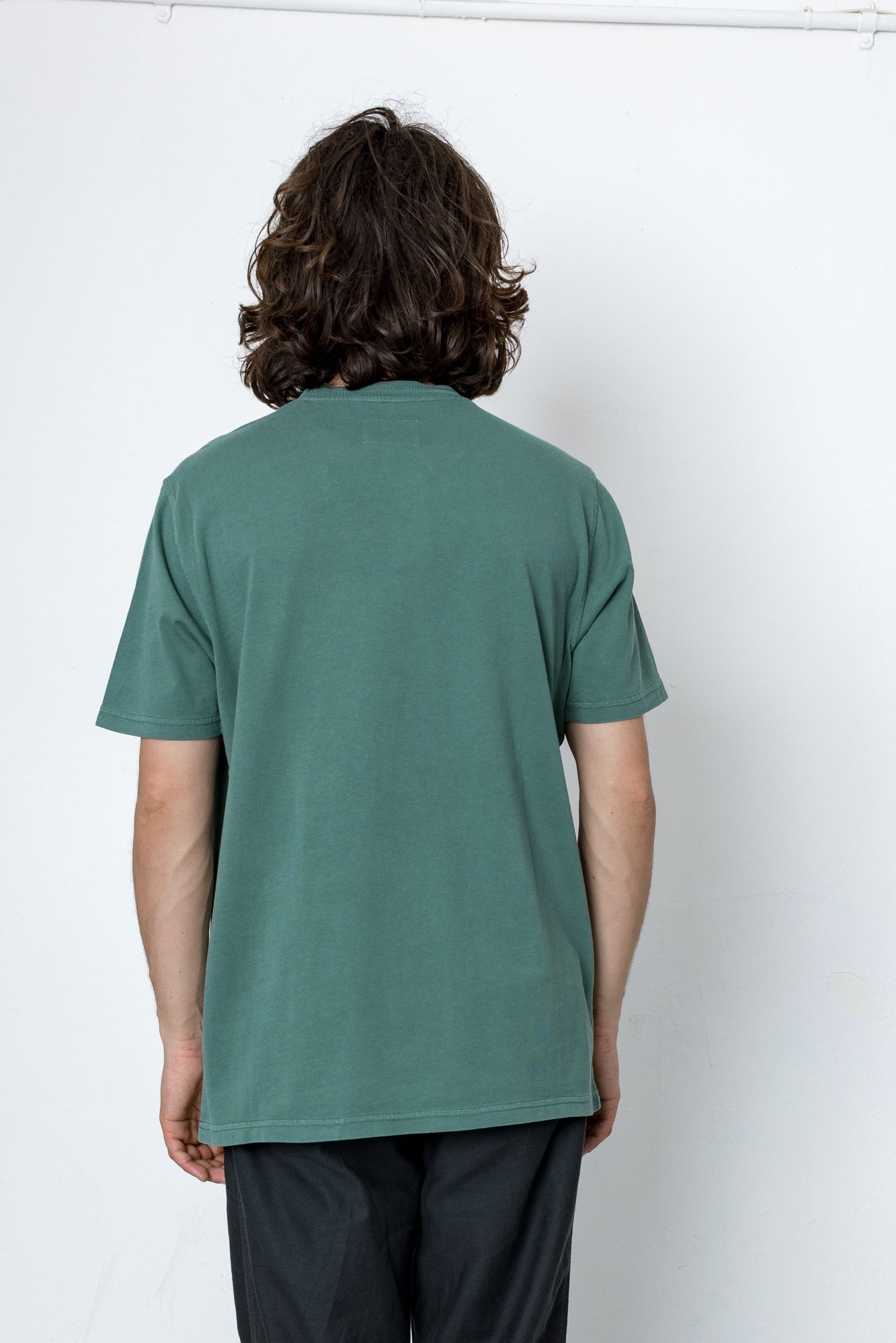 Person wearing a green t-shirt against a white background