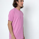 Person wearing a pink t-shirt against a white background