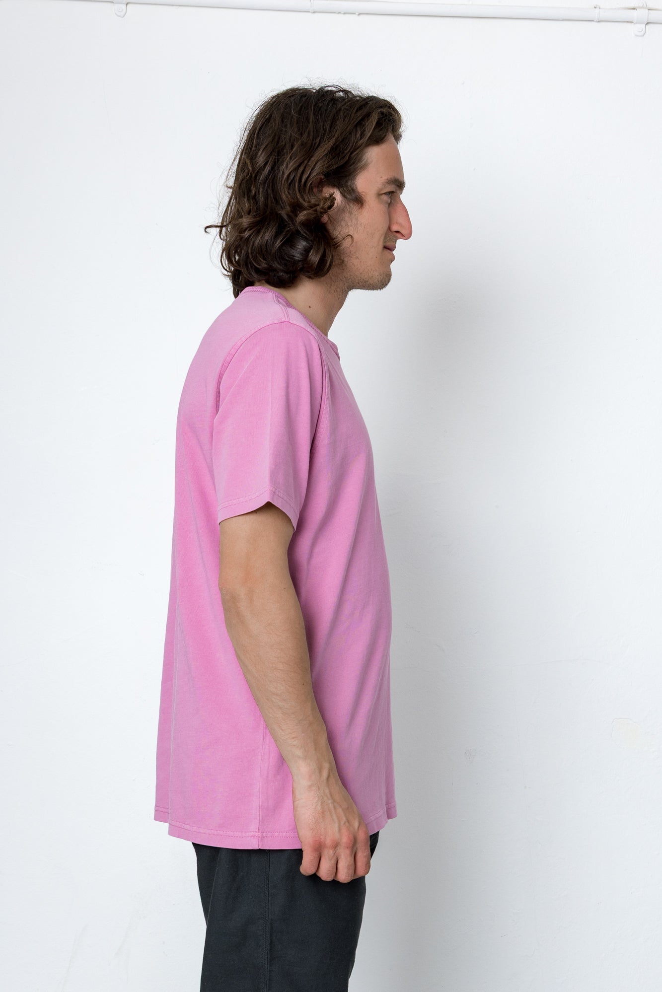 Person wearing a pink t-shirt against a white background