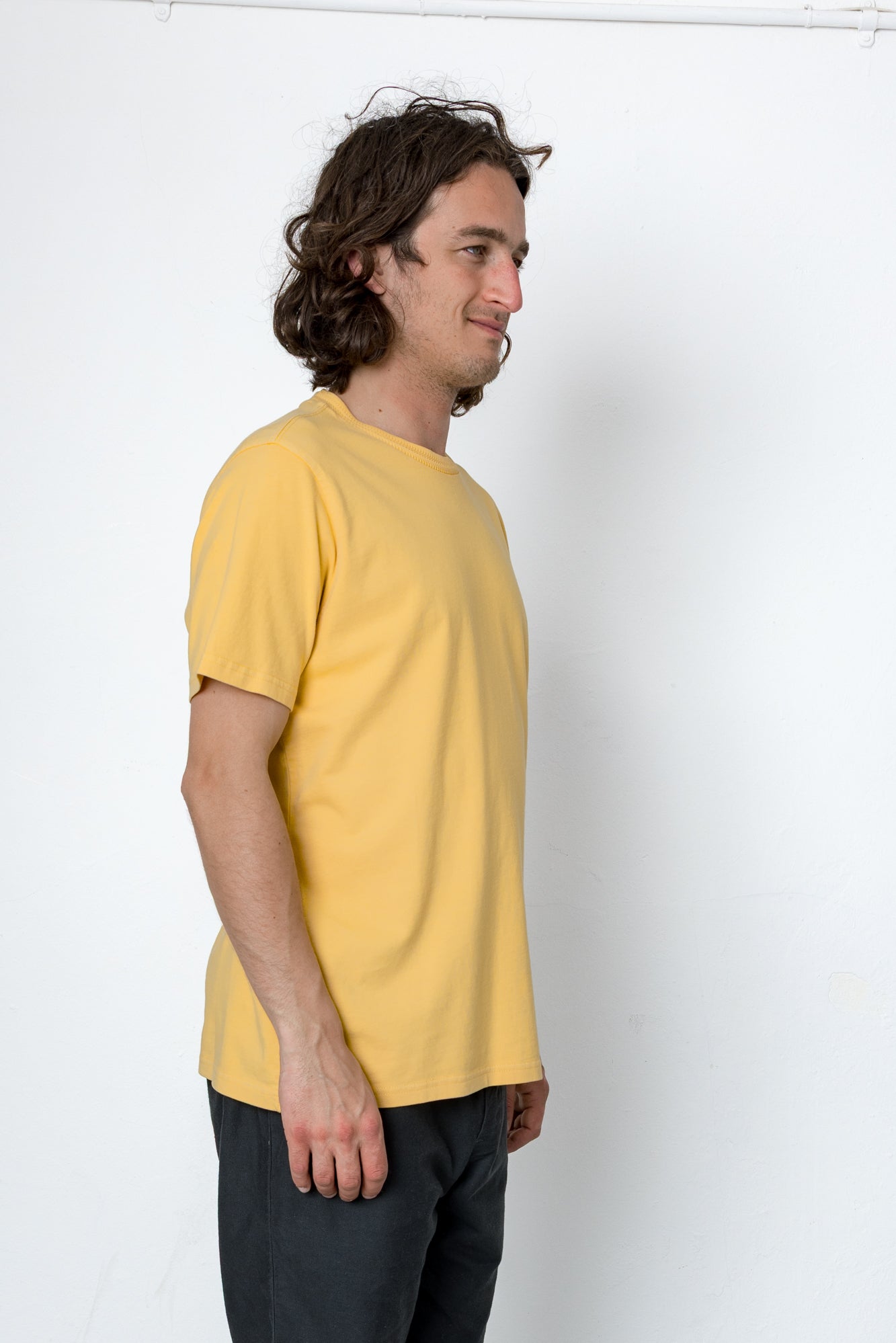 Man wearing a yellow t-shirt against a white background