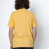 Person wearing a yellow t-shirt and black pants against a white background
