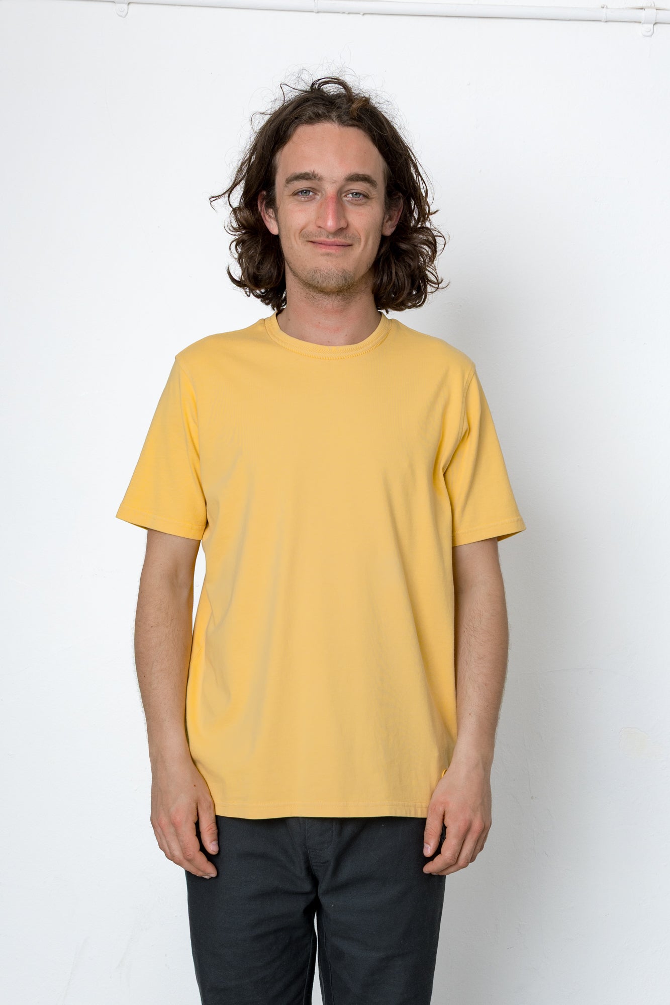Person wearing a yellow t-shirt against a white background