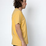 Person wearing a yellow t-shirt against a white background