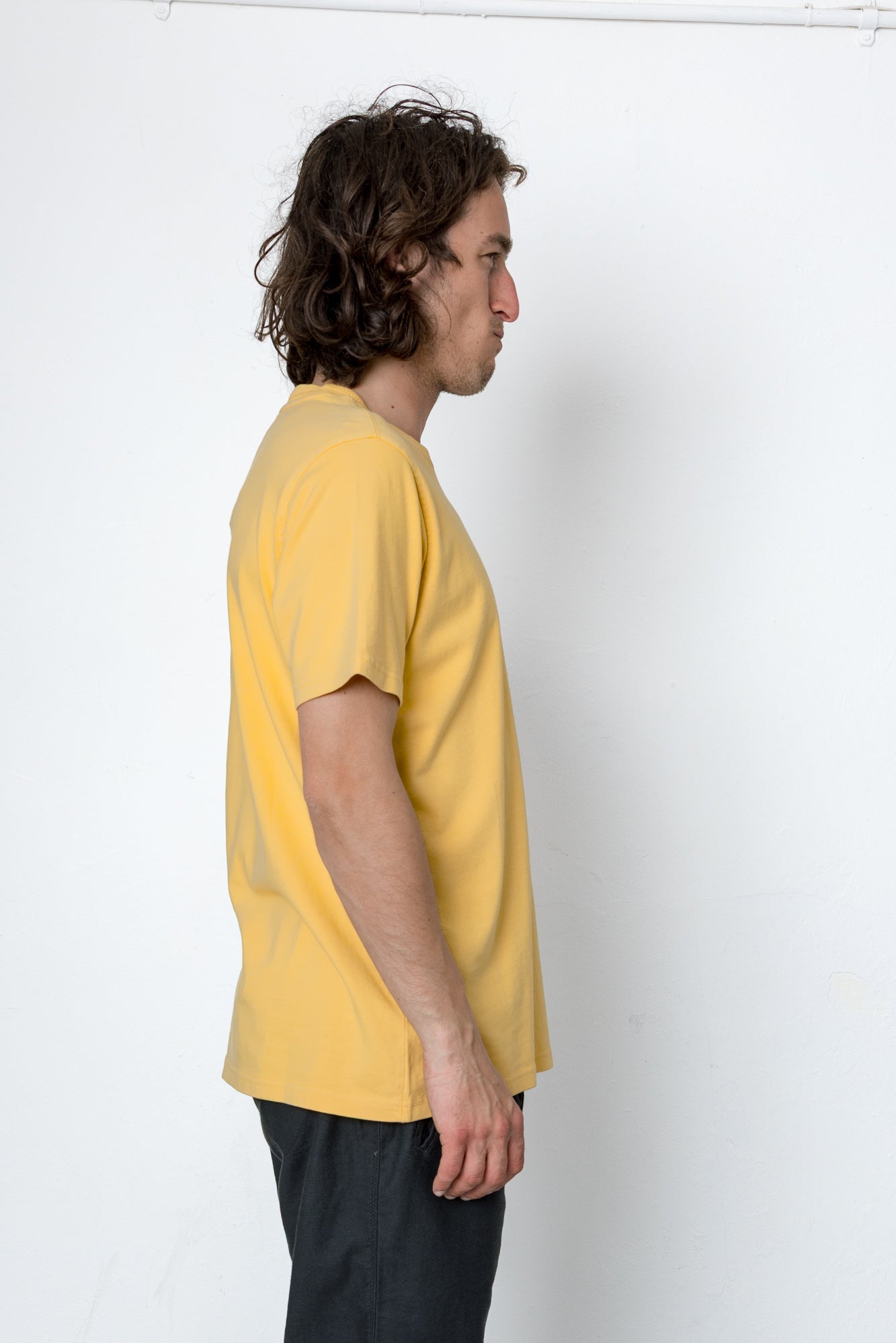 Person wearing a yellow t-shirt against a white background