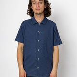 Man wearing a blue short-sleeve shirt against a white background