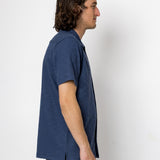 Man wearing a blue shirt against a white background