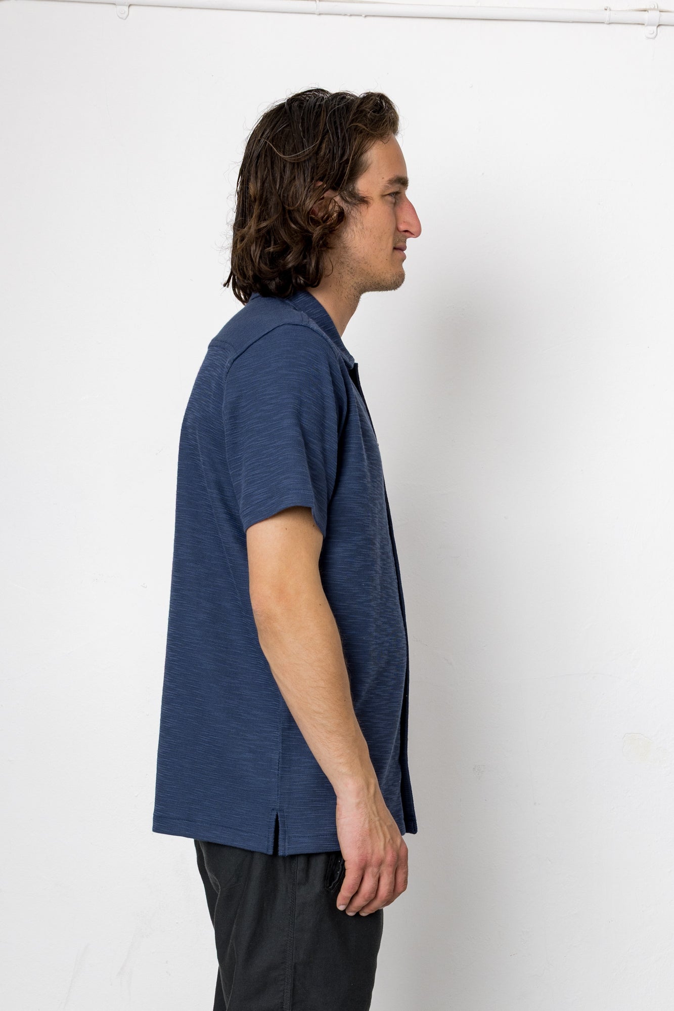 Man wearing a blue shirt against a white background