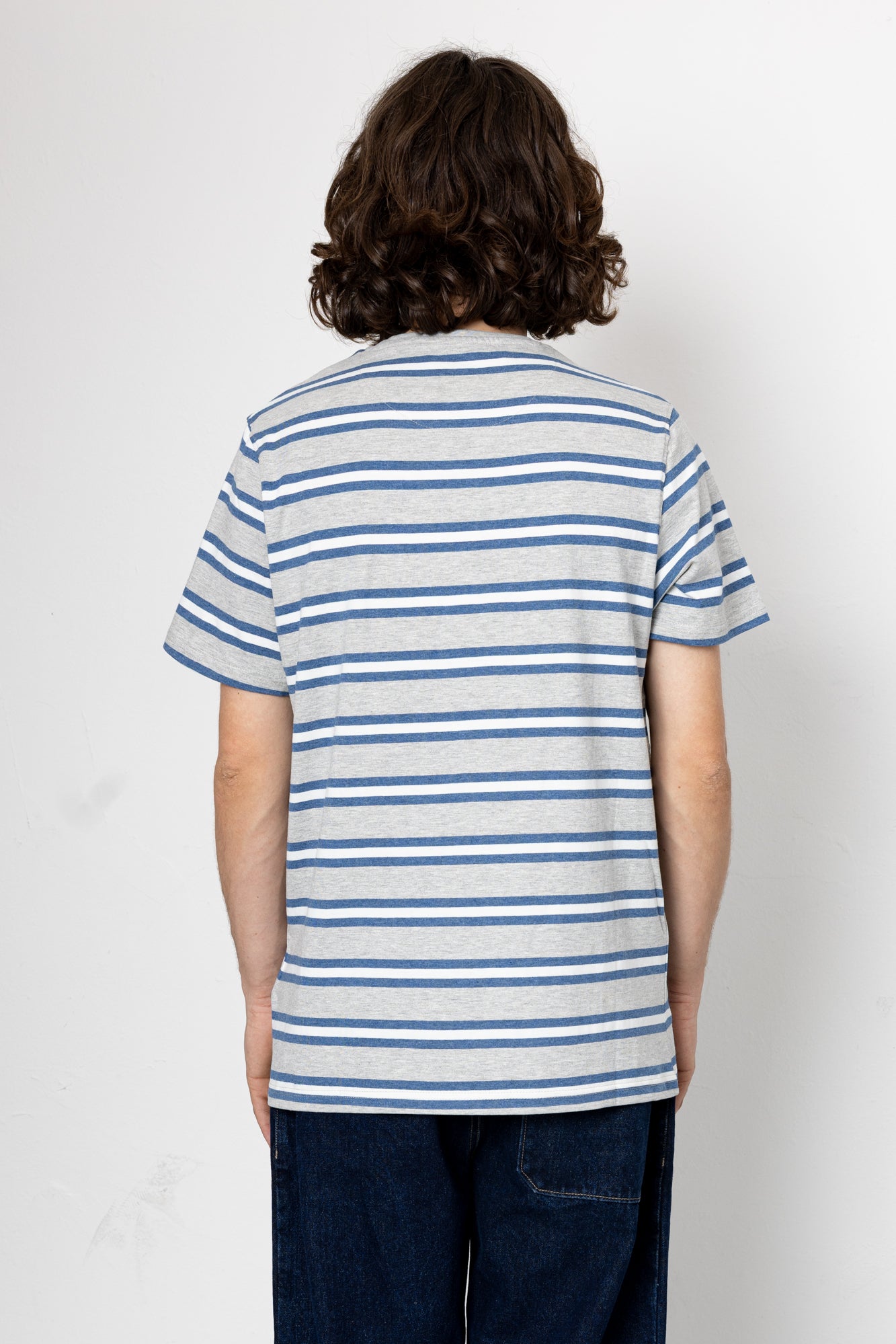 Person wearing a blue and white striped shirt against a plain background