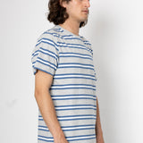 Man wearing a blue and gray striped t-shirt against a white background