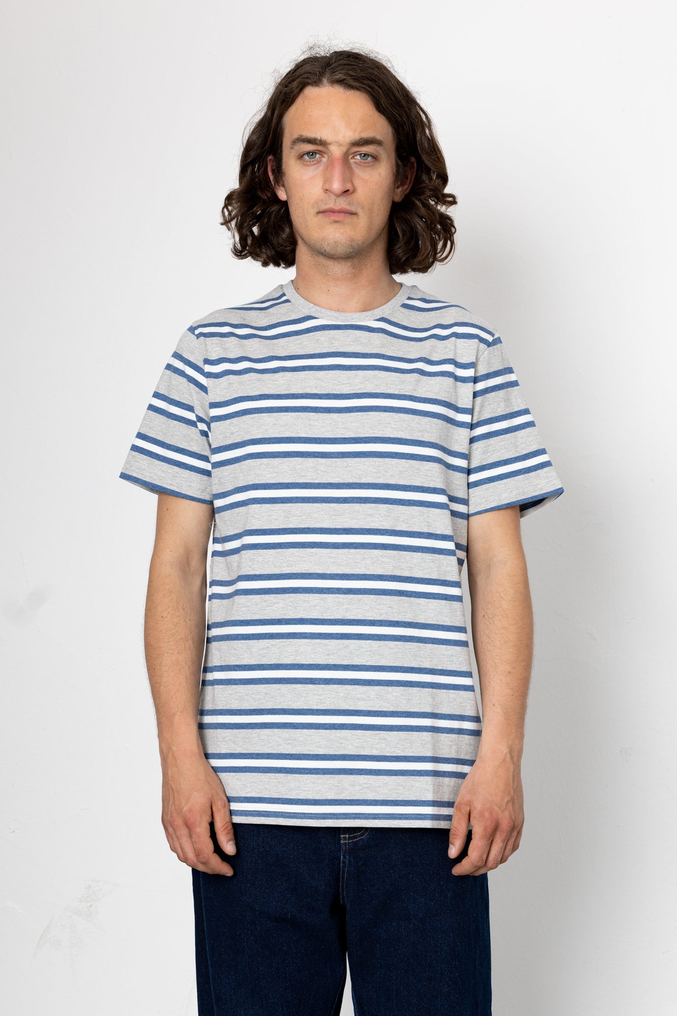 Person wearing a blue and white striped t-shirt against a plain background