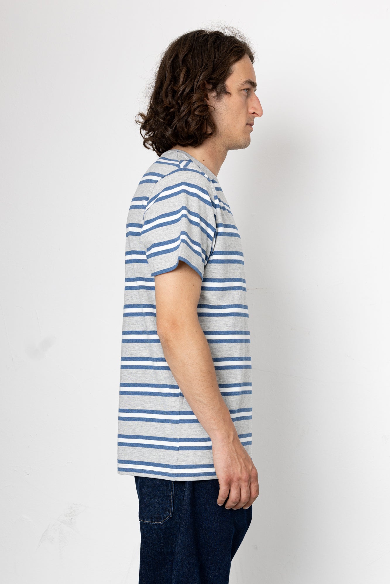 Person wearing a blue and white striped shirt against a plain background
