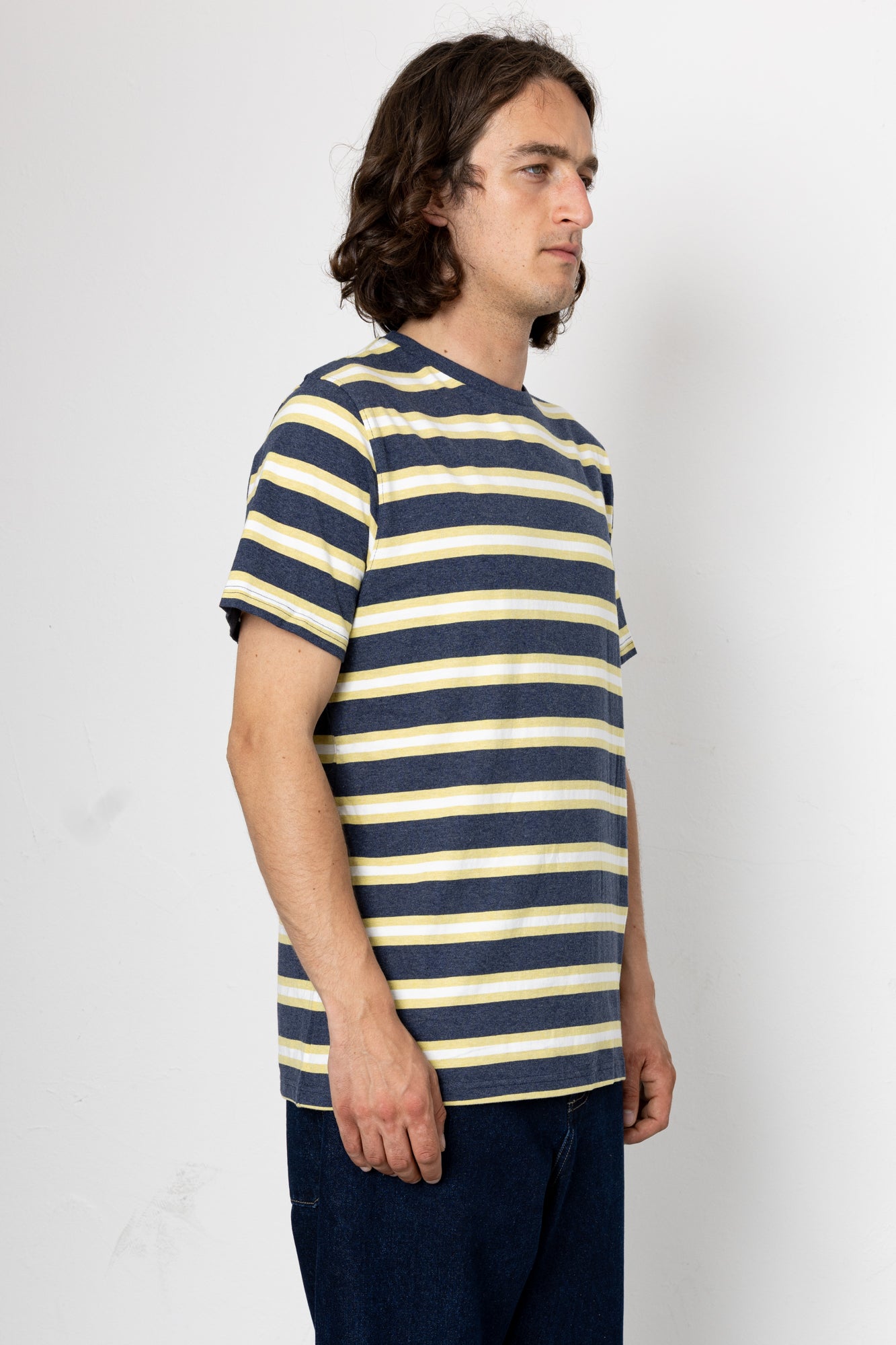 Man wearing a navy and yellow striped shirt against a white background