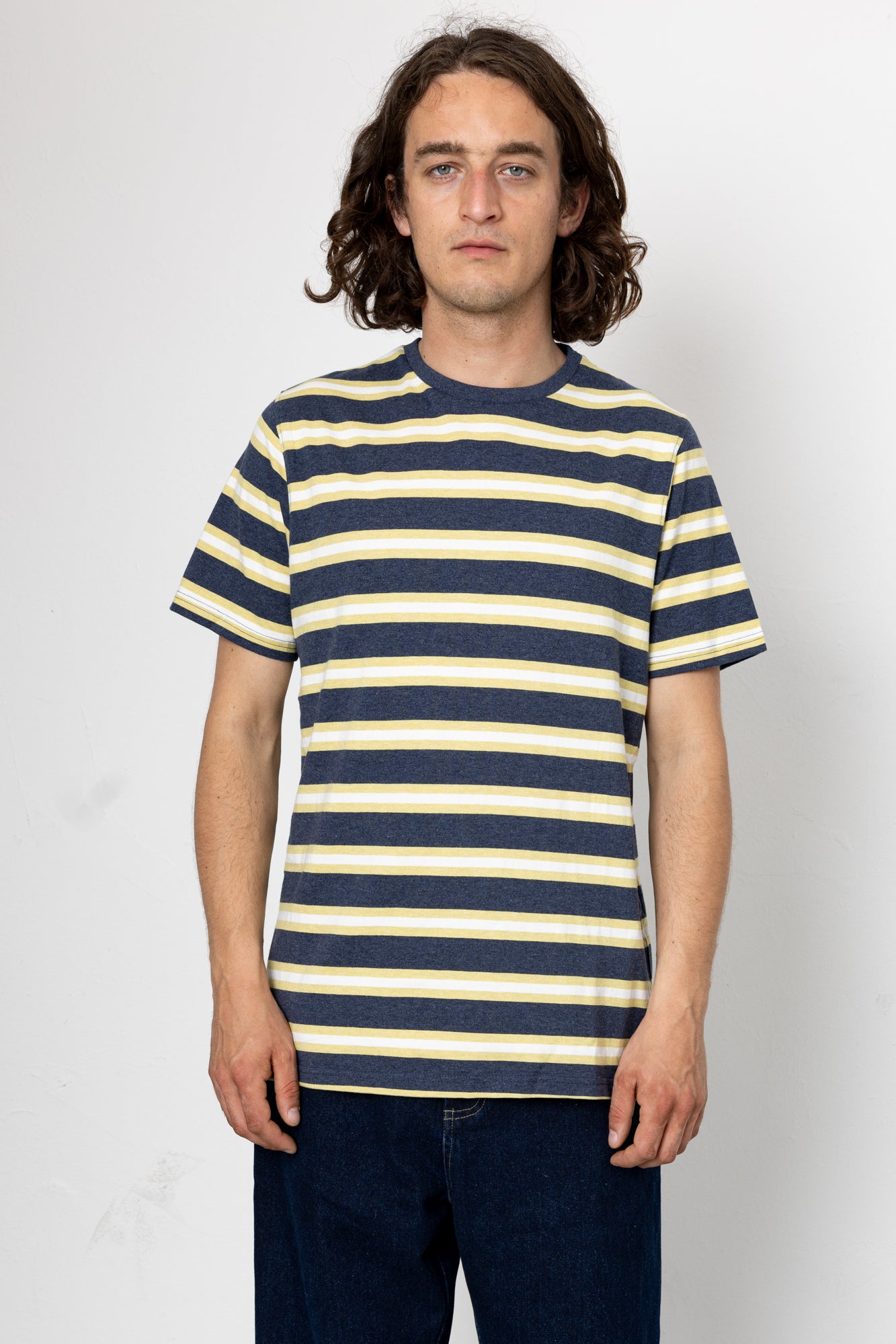 Person wearing a navy and yellow striped t-shirt against a white background