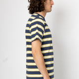Person wearing a navy and yellow striped t-shirt against a white background