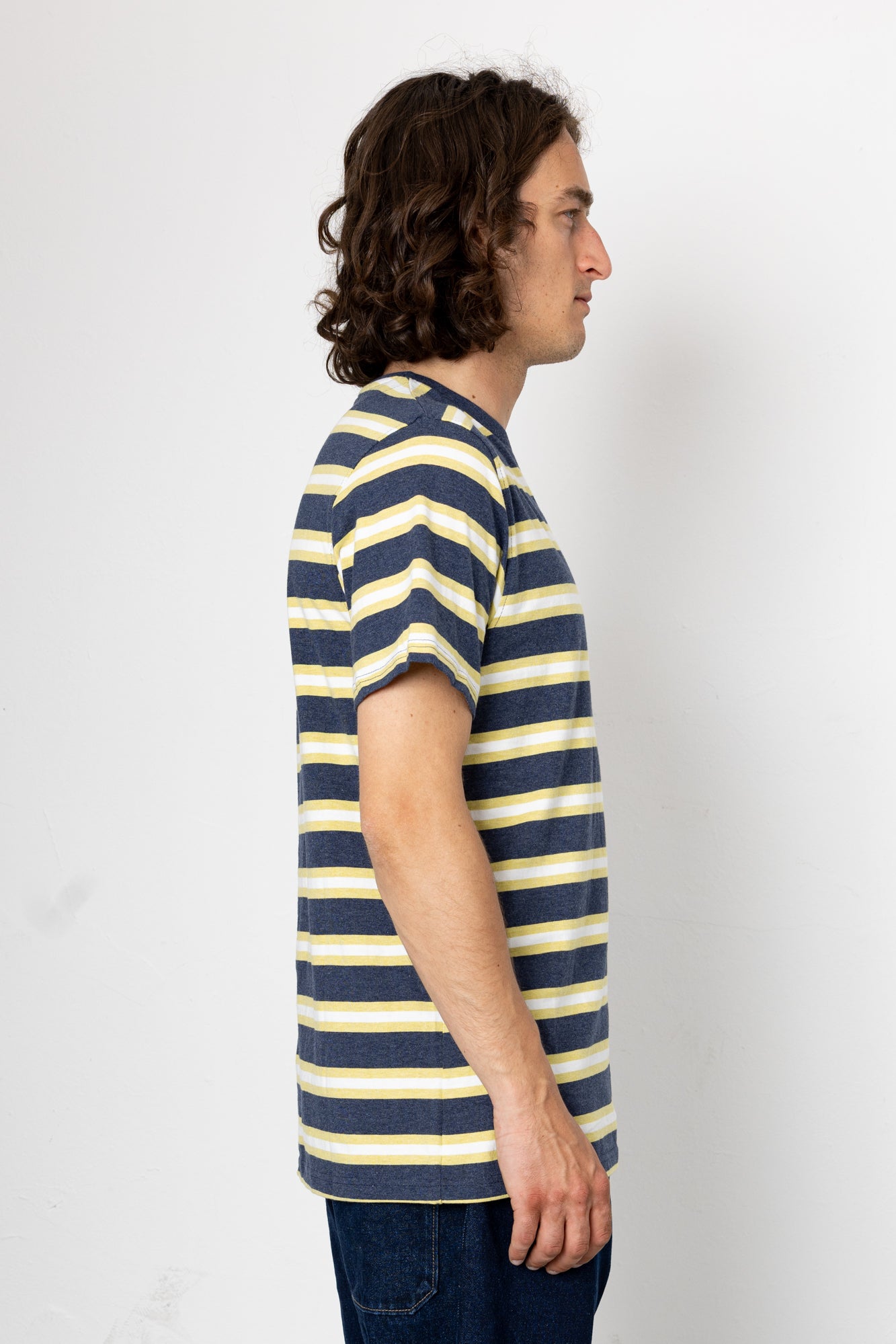 Person wearing a navy and yellow striped t-shirt against a white background