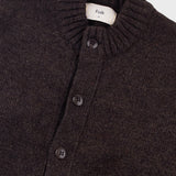 Dark brown knitted cardigan with buttons on a light gray background