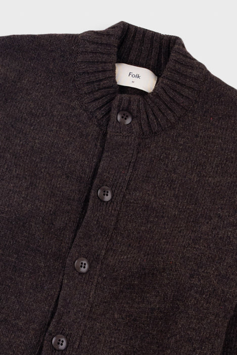 Dark brown knitted cardigan with buttons on a light gray background