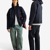 A man and a woman modeling a dark navy hooded jacket, shown from the front and back against a light gray studio background.