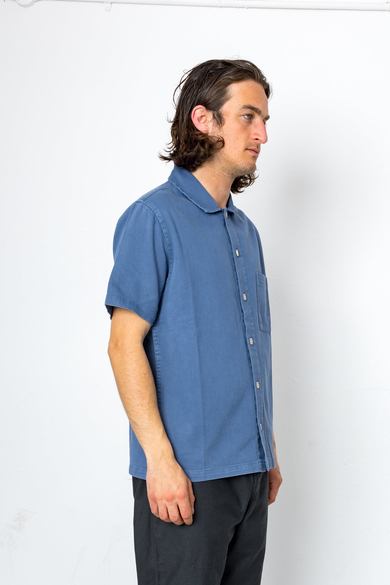 Man wearing blue shirt and black trousers