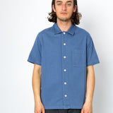 Man wearing blue shirt against a white background