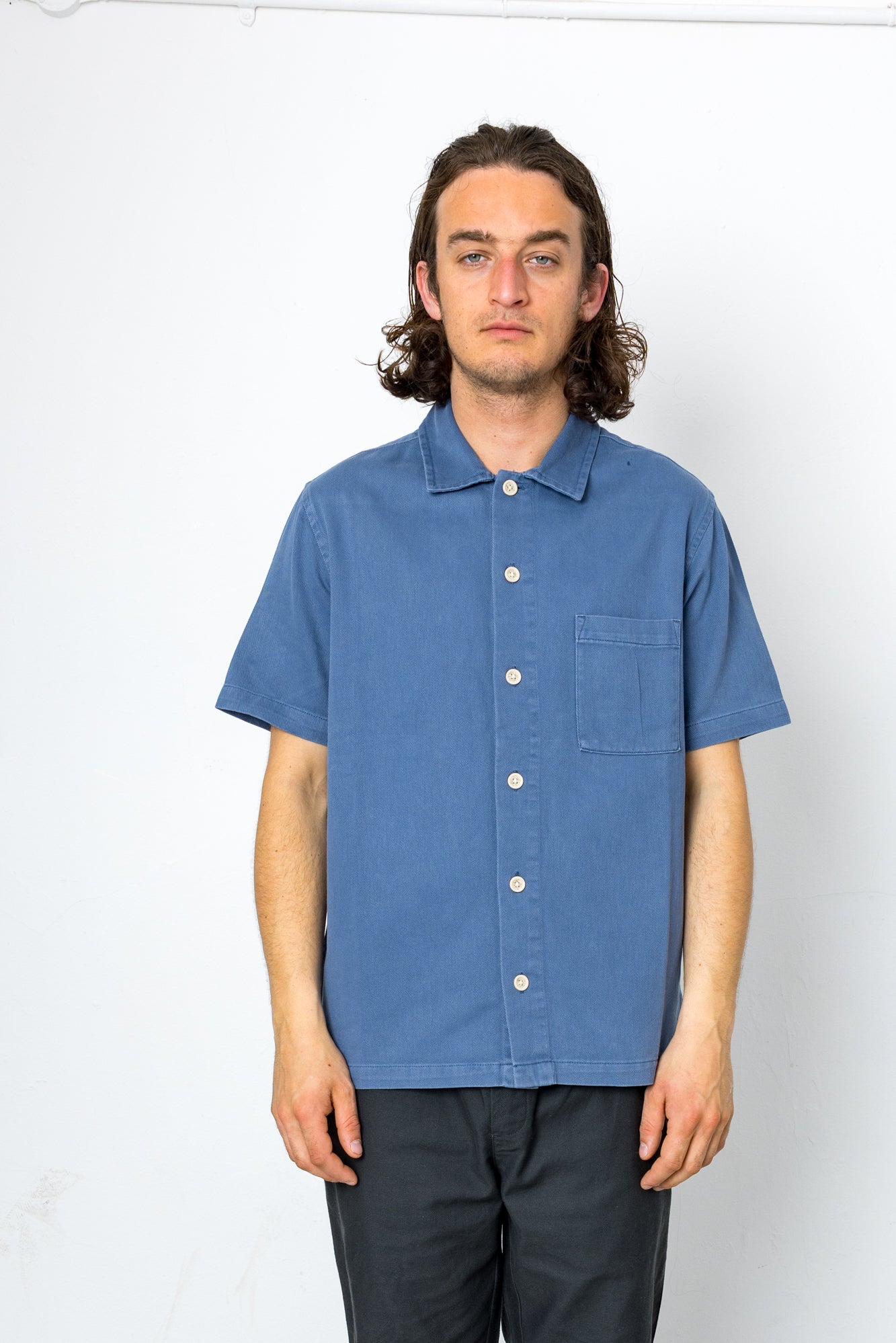 Man wearing blue shirt against a white background