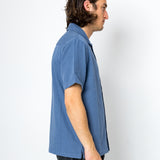 Man wearing a blue shirt against a white background