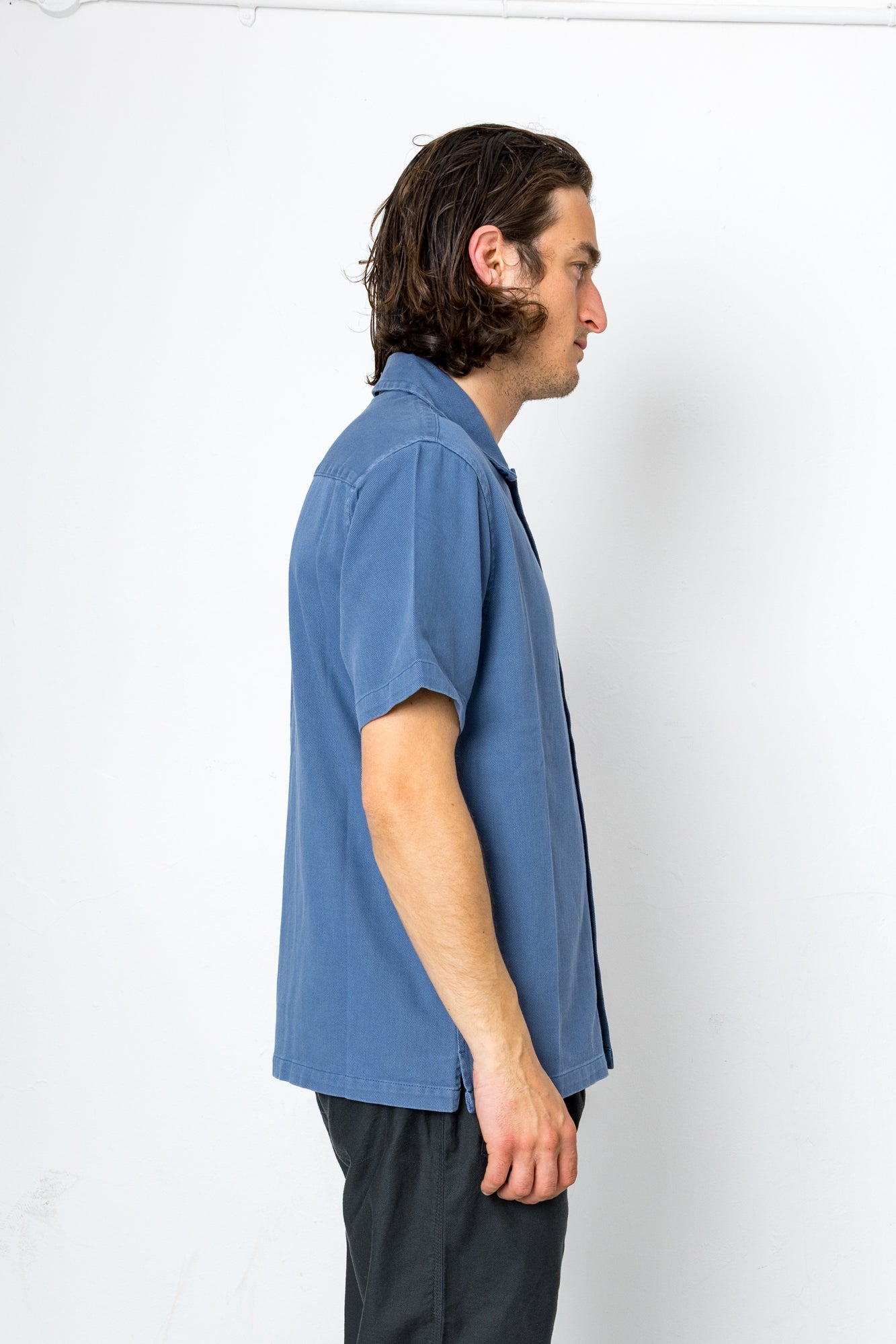 Man wearing a blue shirt against a white background
