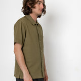 Man wearing an olive green shirt against a white background