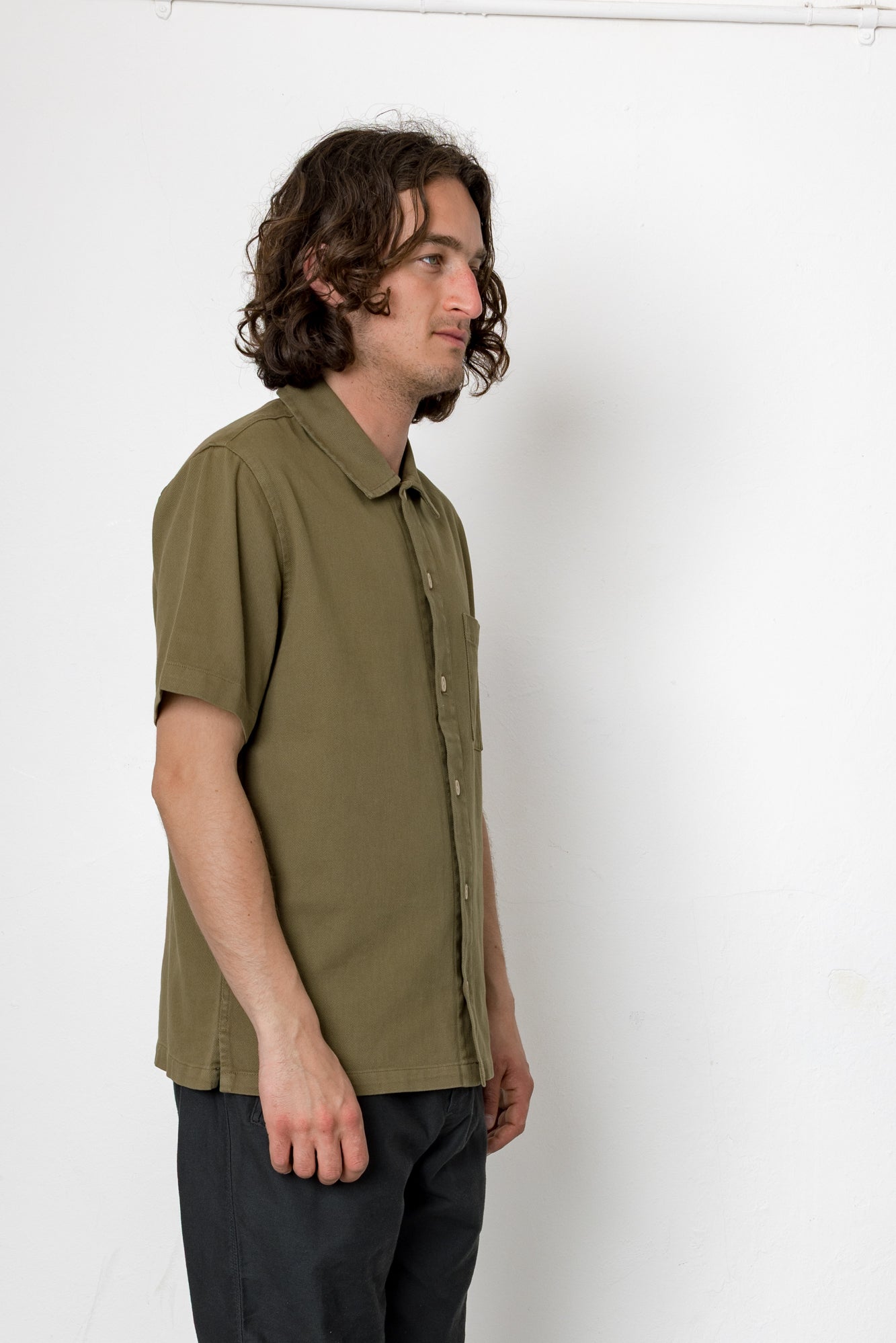 Man wearing an olive green shirt against a white background