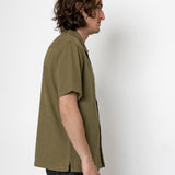Man wearing a green shirt against a white background