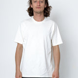 Person wearing a plain white t-shirt against a white background