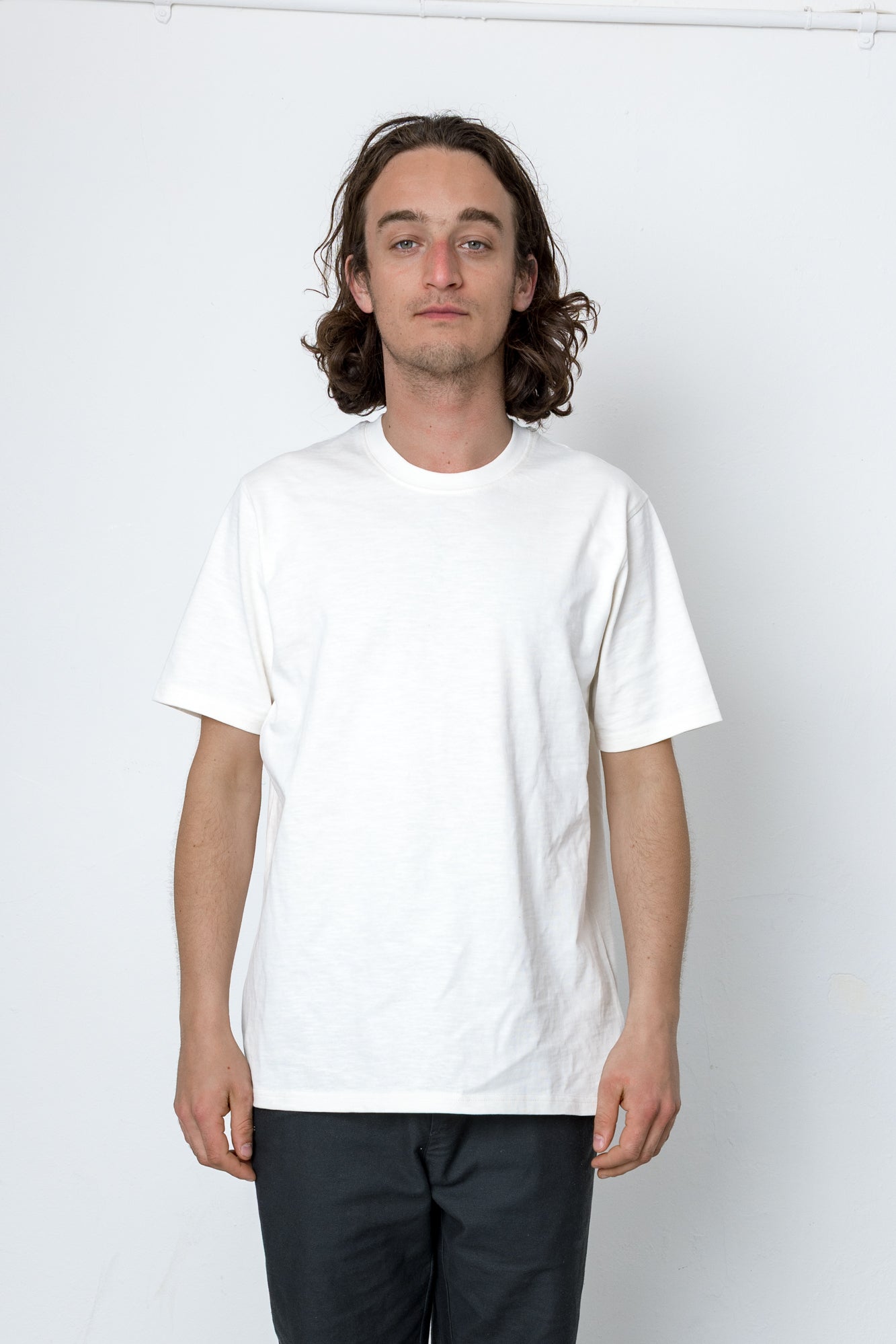 Person wearing a plain white t-shirt against a white background