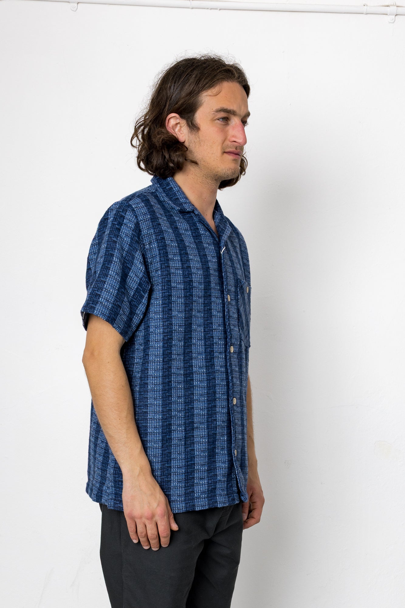 Man wearing a blue patterned shirt against a white background