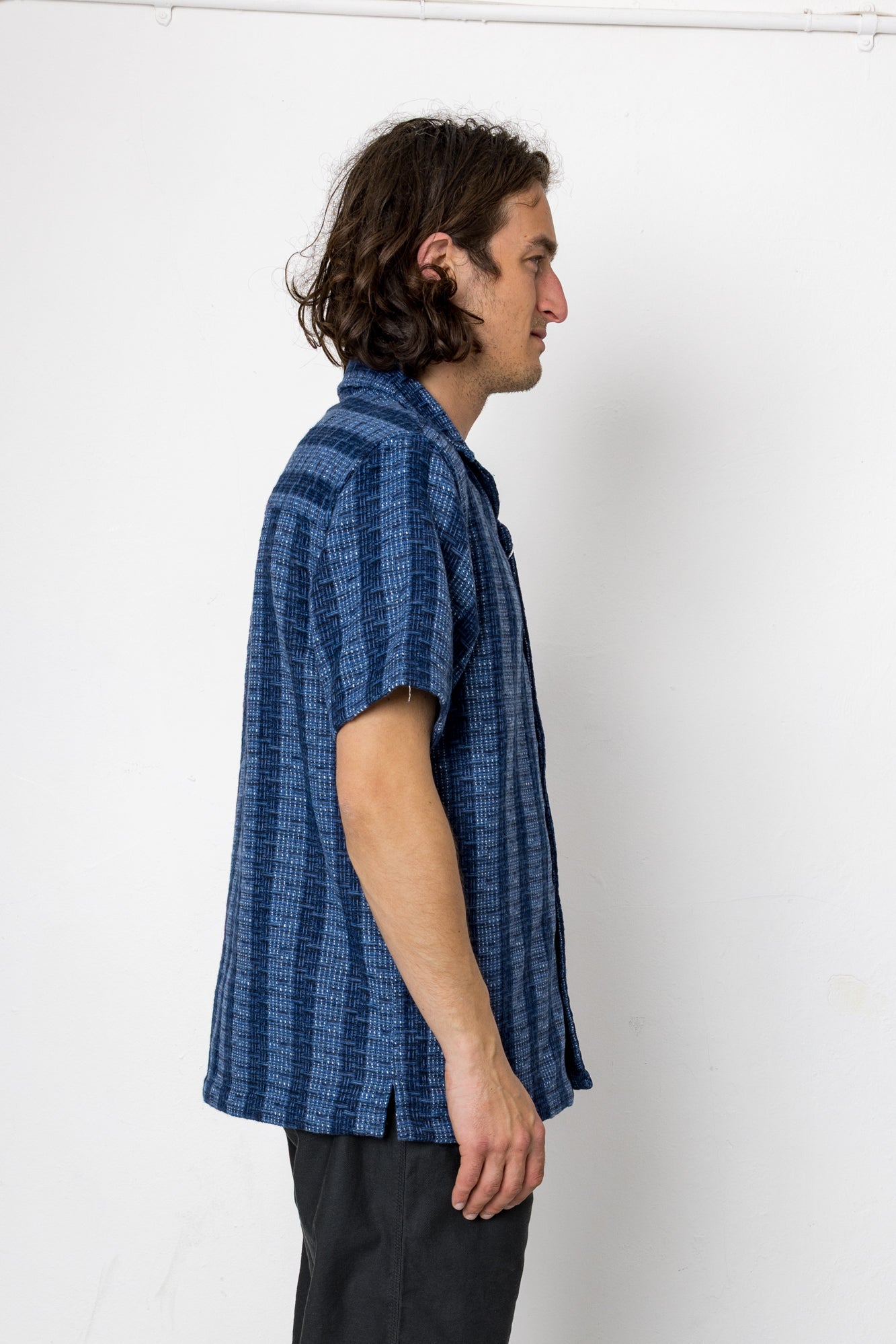 Man wearing a blue patterned shirt against a white background