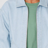 Light blue striped shirt over a green t-shirt on a neutral background
